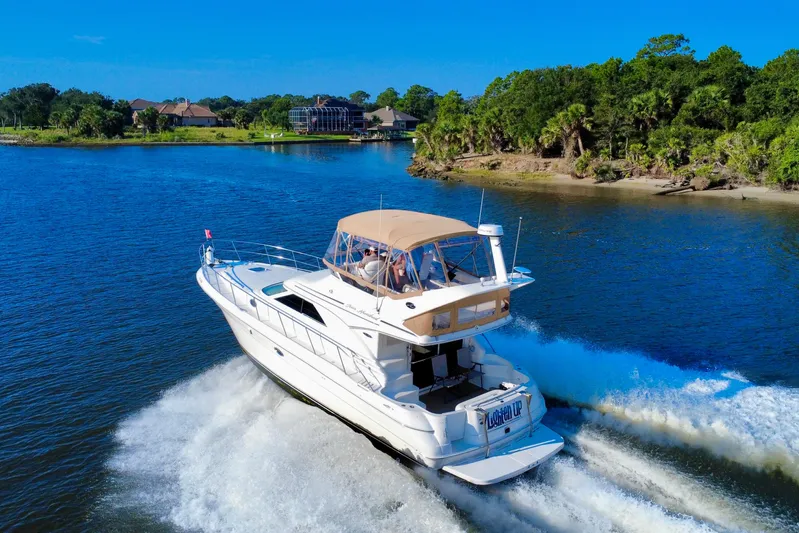Lighten Up Yacht Photos Pics 2003 Sea Ray 400 Sedan Bridge cruising on a scenic river with lush greenery.