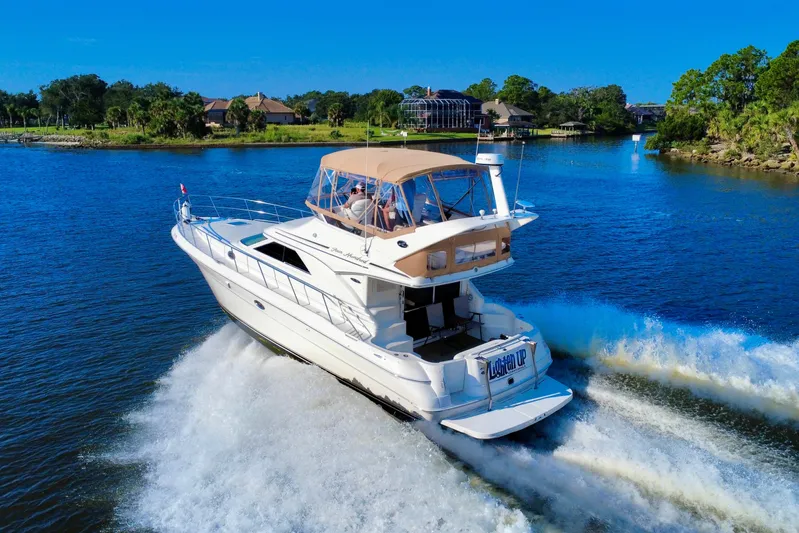 Lighten Up Yacht Photos Pics 2003 Sea Ray 400 Sedan Bridge cruising on a scenic waterway under clear blue skies.