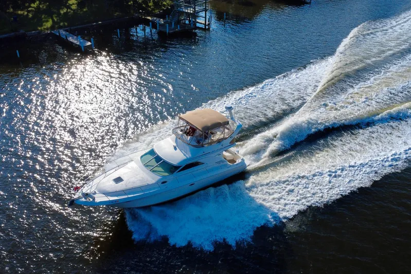 Lighten Up Yacht Photos Pics 2003 Sea Ray 400 Sedan Bridge cruising on a sunlit waterway.