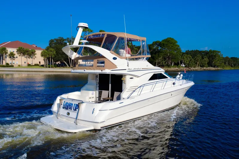 Lighten Up Yacht Photos Pics 2003 Sea Ray 400 Sedan Bridge cruising on a scenic waterway under clear blue skies.