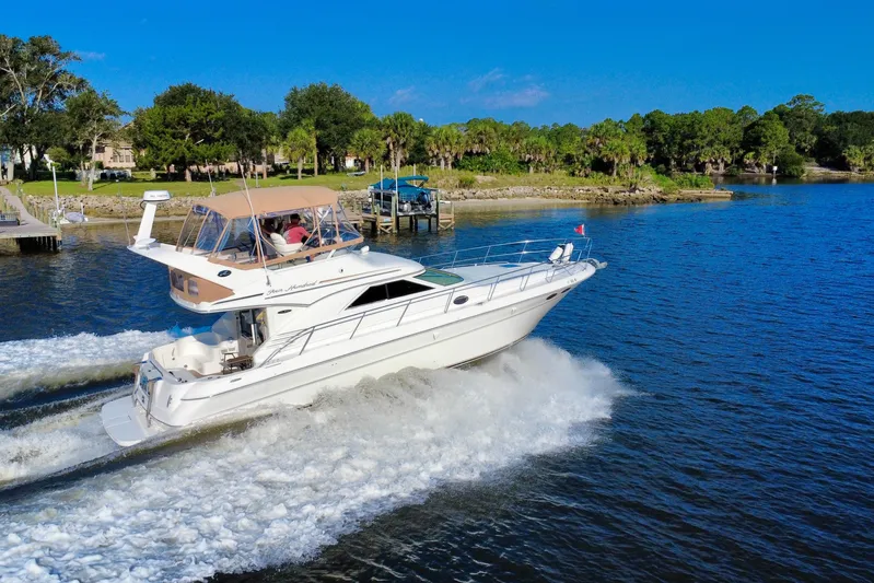 Lighten Up Yacht Photos Pics 2003 Sea Ray 400 Sedan Bridge cruising on a scenic river under a clear blue sky.