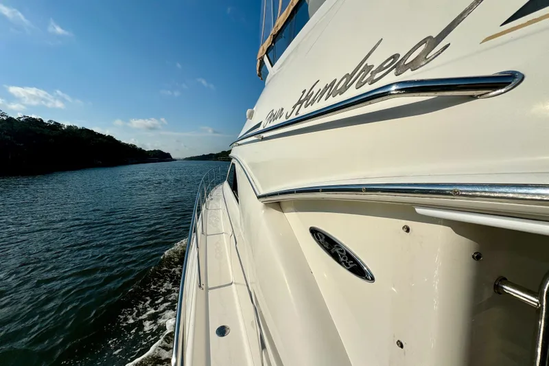 Lighten Up Yacht Photos Pics 2003 Sea Ray 400 Sedan Bridge cruising on a scenic waterway under a clear blue sky.