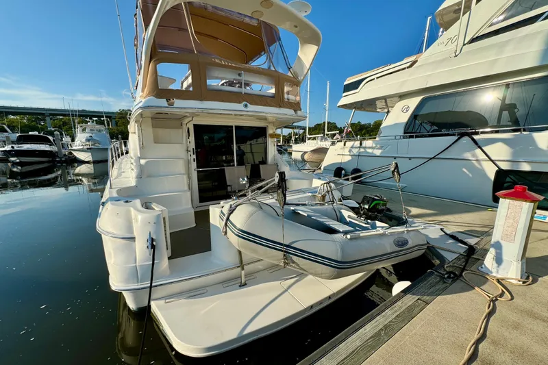 Lighten Up Yacht Photos Pics 2003 Sea Ray 400 Sedan Bridge yacht docked with inflatable boat on platform.
