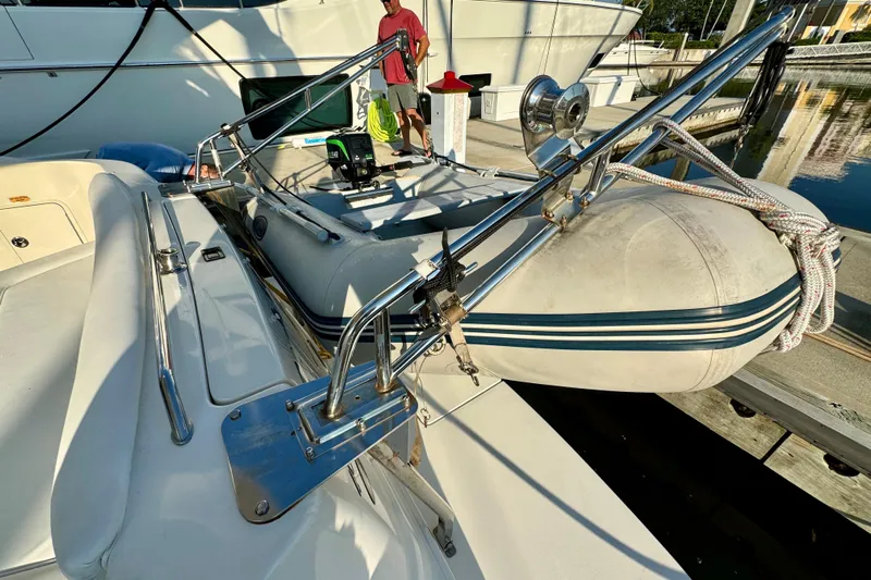 Lighten Up Yacht Photos Pics 2003 Sea Ray 400 Sedan Bridge with dinghy on deck at marina.