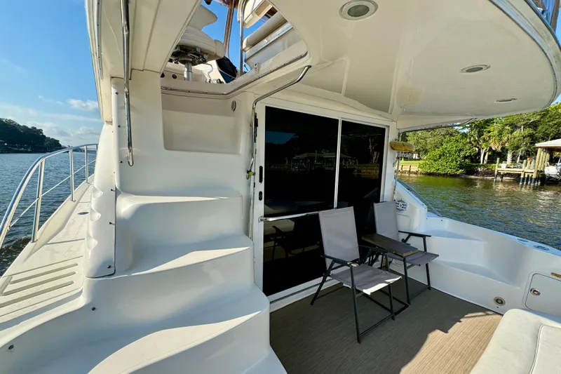Lighten Up Yacht Photos Pics 2003 Sea Ray 400 Sedan Bridge yacht with outdoor seating, docked by a scenic waterfront.