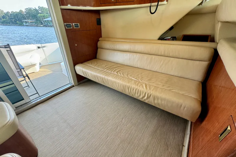 Lighten Up Yacht Photos Pics Interior of 2003 Sea Ray 400 Sedan Bridge with beige leather seating and lake view.