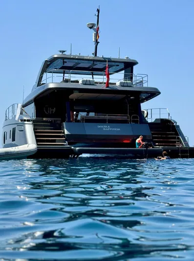 Double Happiness Yacht Photos Pics 2024 Sunreef 60 yacht on calm blue water, rear view.