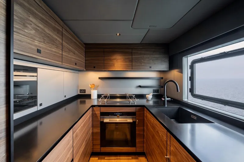 Double Happiness Yacht Photos Pics Modern kitchen interior on 2024 Sunreef 60 yacht with sleek wood cabinetry and ocean view.