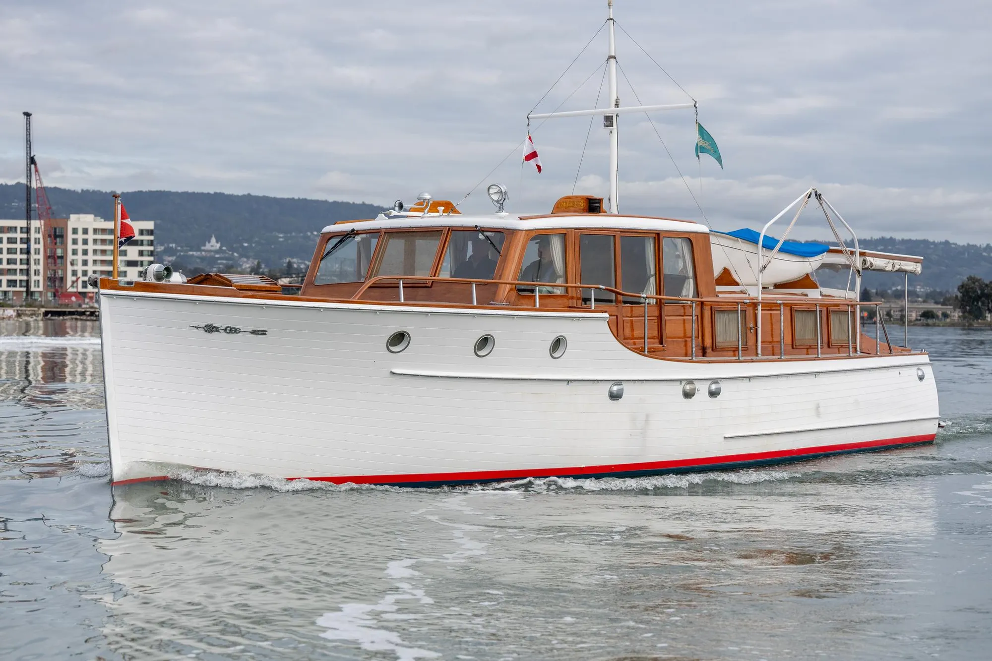 1939 Stephens Brothers Bridgedeck Cruiser on calm water, showcasing classic wooden design.