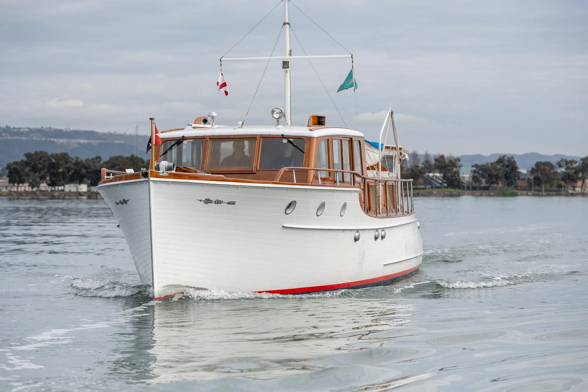 1939 Stephens Brothers Bridgedeck Cruiser on calm water, showcasing classic wooden design.