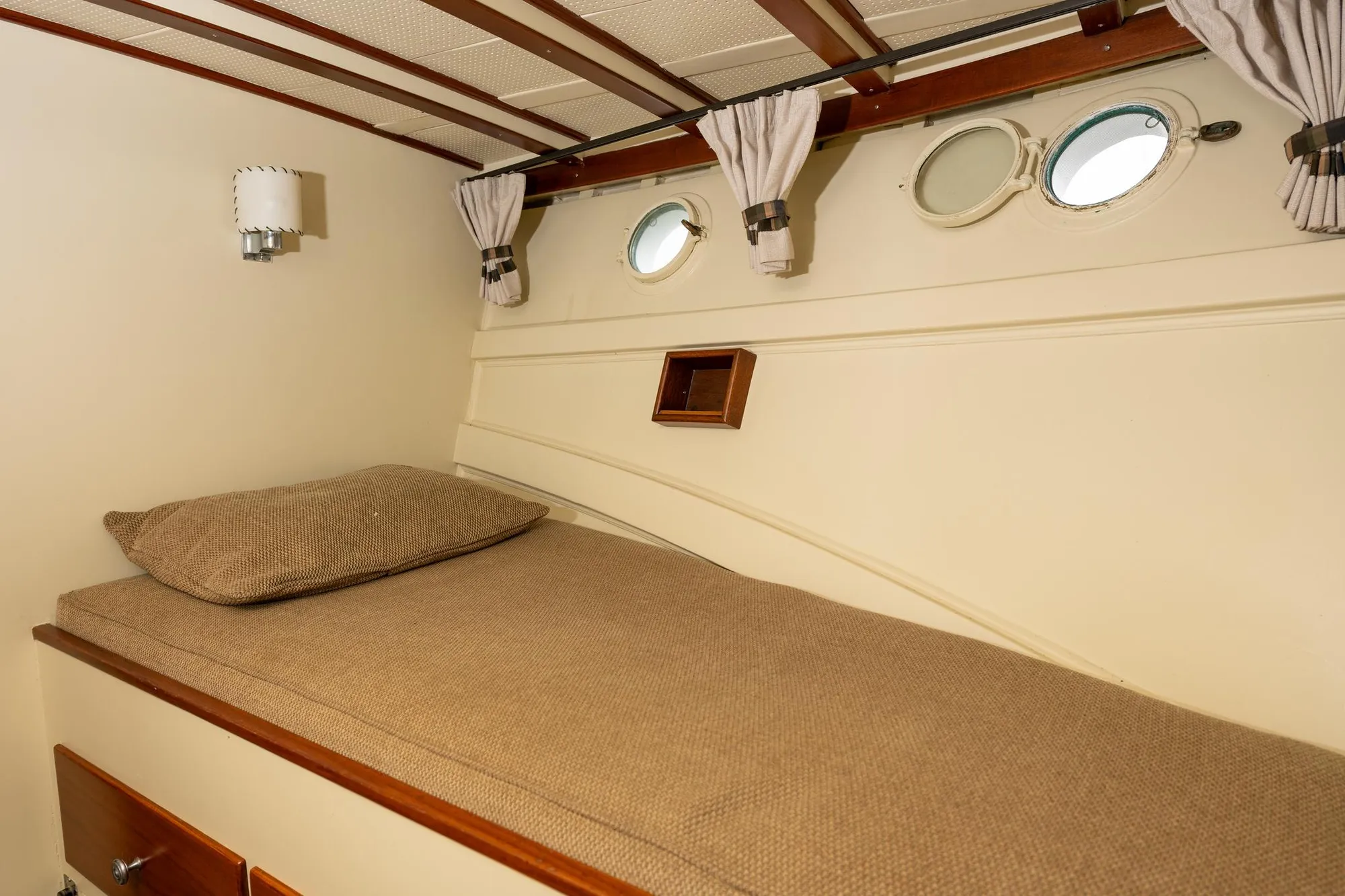 1939 Stephens Brothers Bridgedeck Cruiser cabin interior with bed and portholes.