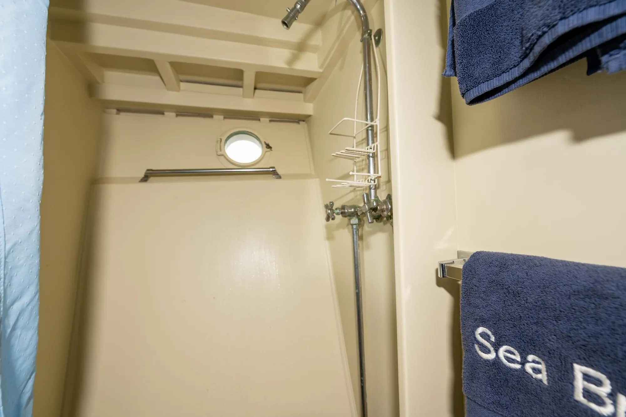 Shower area in 1939 Stephens Brothers Bridgedeck Cruiser with porthole and blue towels.