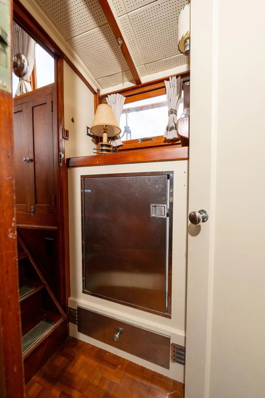 Interior of 1939 Stephens Brothers Bridgedeck Cruiser with wooden accents and metal cabinet.