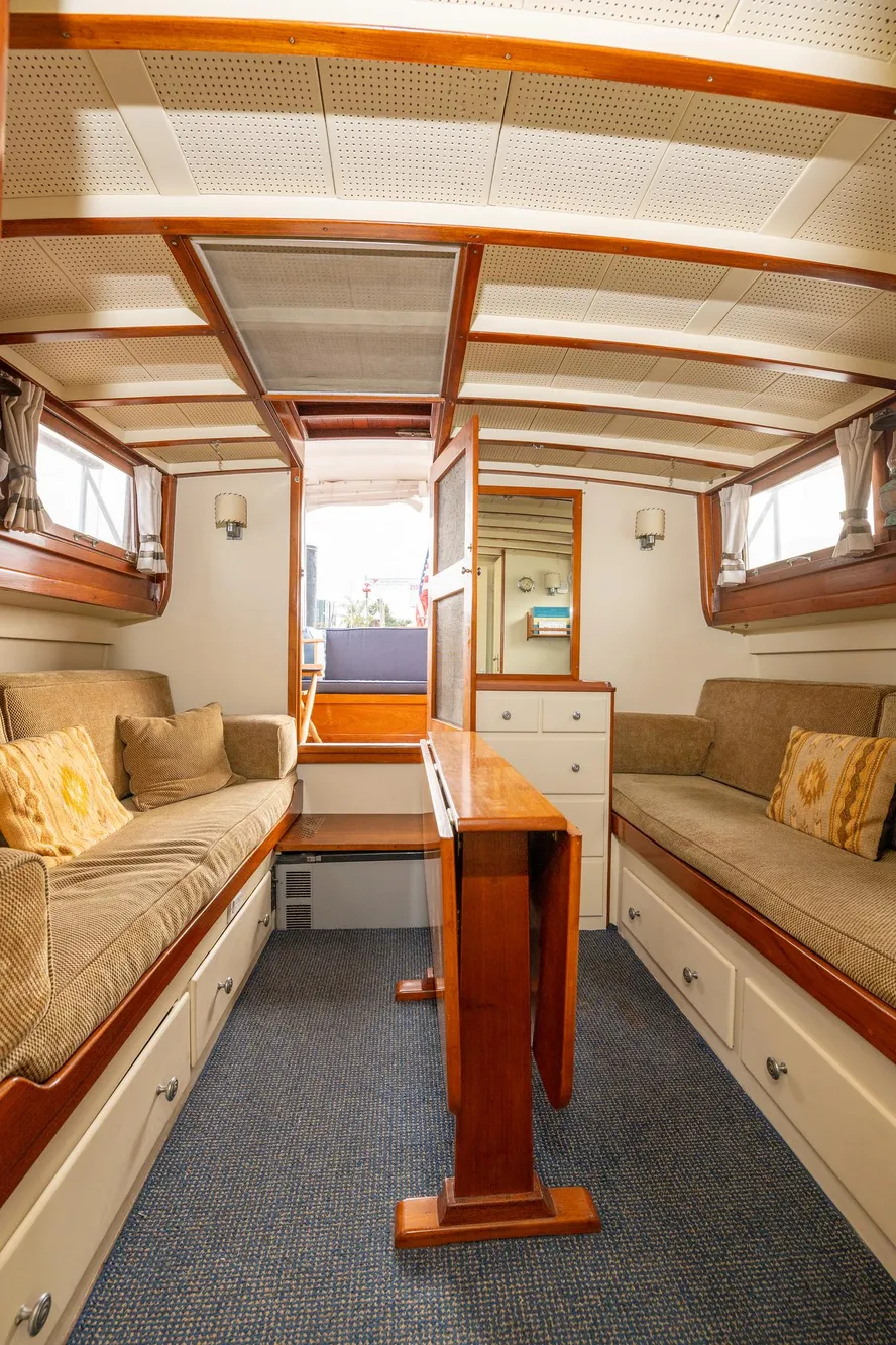 Interior of 1939 Stephens Brothers Bridgedeck Cruiser with wooden furnishings and cozy seating.