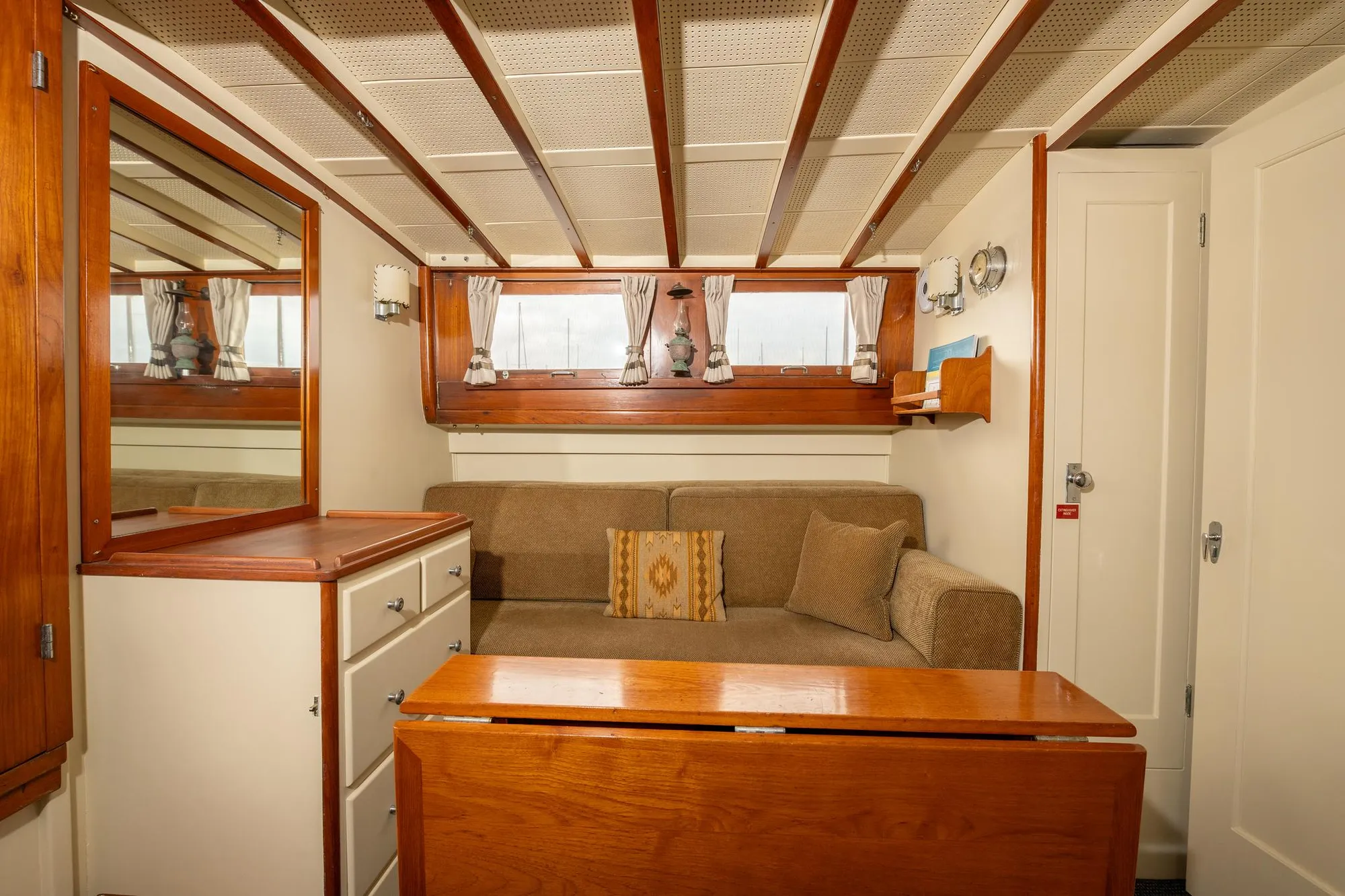 Interior of 1939 Stephens Brothers Bridgedeck Cruiser with cozy seating and wooden accents.