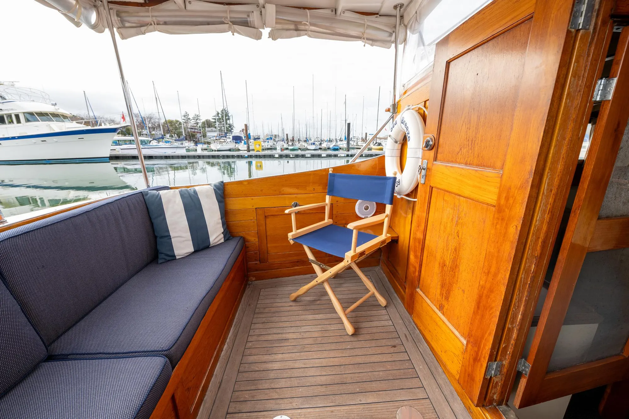 1939 Stephens Brothers Bridgedeck Cruiser interior with wooden paneling and seating at marina.
