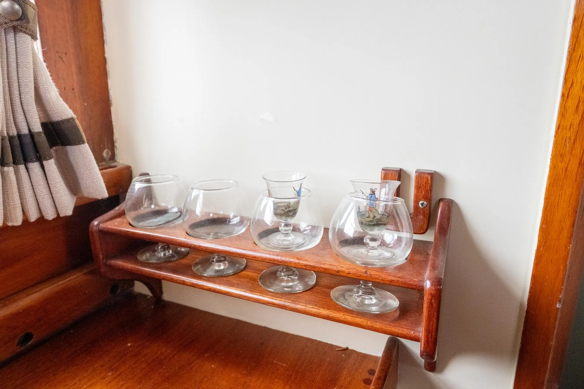 Vintage glass holder on 1939 Stephens Brothers Bridgedeck Cruiser, featuring wooden craftsmanship.