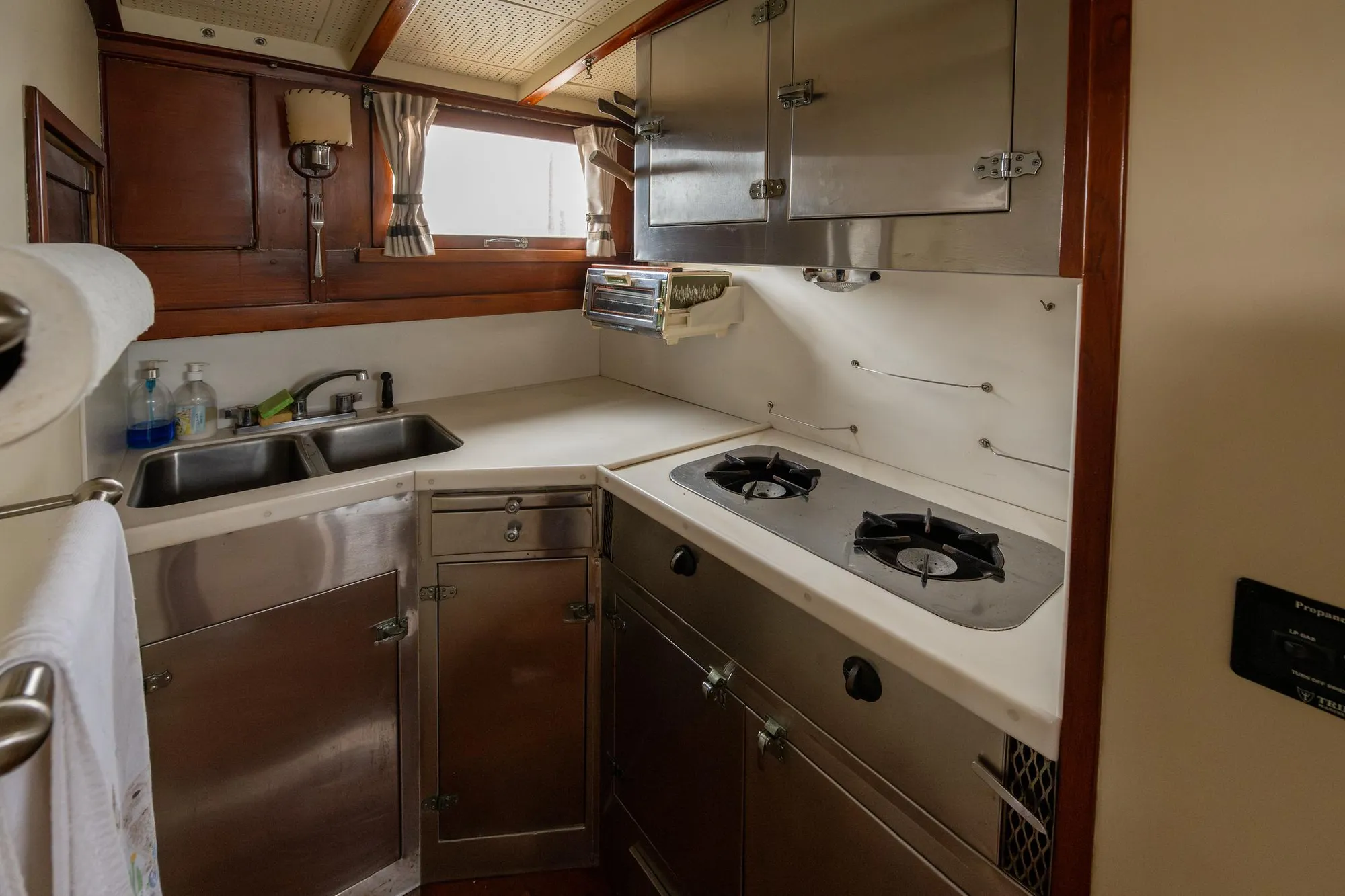 1939 Stephens Brothers Bridgedeck Cruiser kitchen with stainless steel appliances and wooden cabinetry.