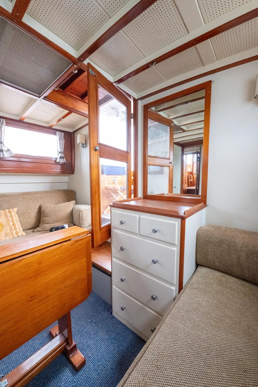 Interior of 1939 Stephens Brothers Bridgedeck Cruiser with wood accents and cozy seating.