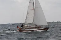 Sailboat on open water, Custom Scalar 28, 1977 model, cloudy sky.