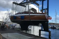 Custom Scalar 28 sailboat from 1977 being lifted at a marina.