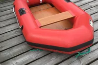 Red inflatable boat on wooden dock, Custom Scalar 28, 1977 model.
