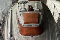 Vintage 1977 Custom Scalar 28 boat with wooden deck, docked indoors.