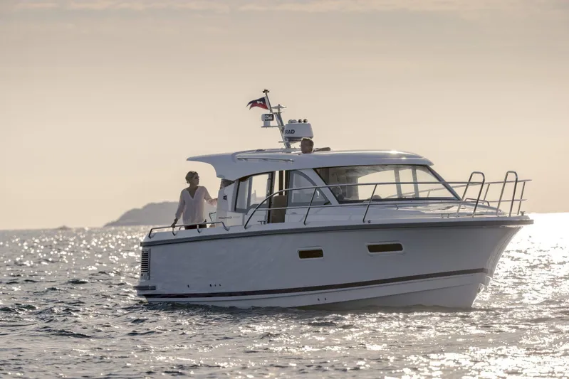  Yacht Photos Pics 2025 Nimbus 305 Coupe cruising on serene waters at sunset.