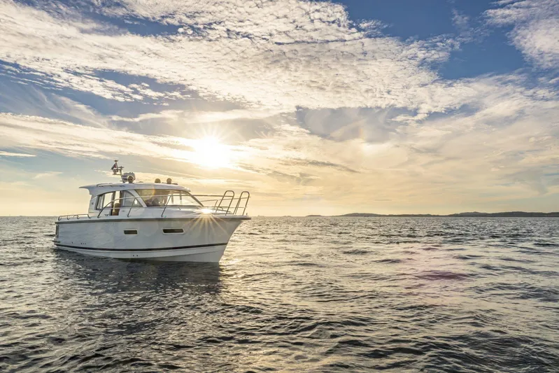  Yacht Photos Pics Nimbus 305 Coupe 2025 cruising on open water at sunset.