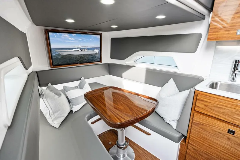  Yacht Photos Pics Luxurious interior of 2026 Valhalla Boatworks V-46 with elegant seating and wooden table.