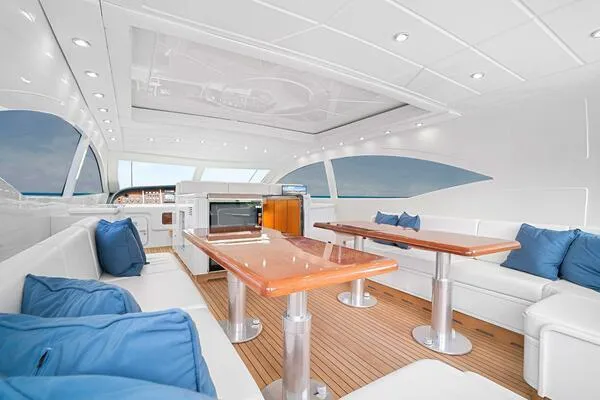  Yacht Photos Pics Luxurious interior of 2001 Mangusta 72 Open yacht with white seating and blue cushions.