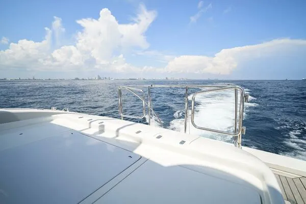  Yacht Photos Pics Mangusta 72 Open yacht cruising on open sea, 2001 model, clear sky, distant city skyline.