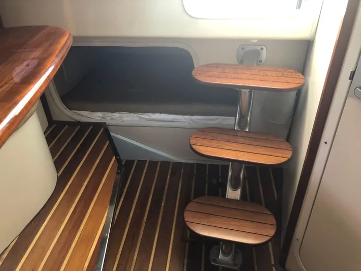  Yacht Photos Pics 2007 Pursuit 335 Offshore cabin interior with wooden steps and cozy sleeping area.