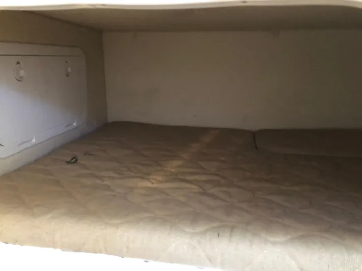  Yacht Photos Pics Interior cabin of a 2007 Pursuit 335 Offshore boat with a beige mattress.