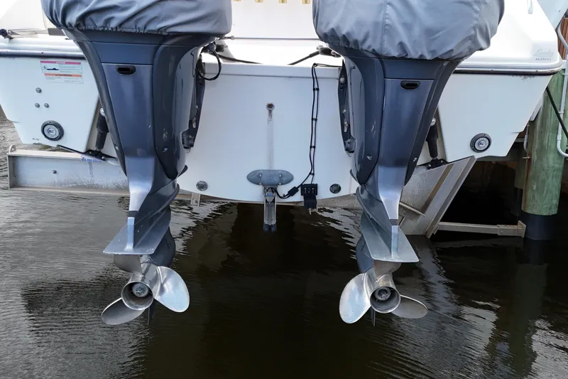  Yacht Photos Pics 2007 Pursuit OS 335 Offshore boat with dual outboard motors, docked on calm water.