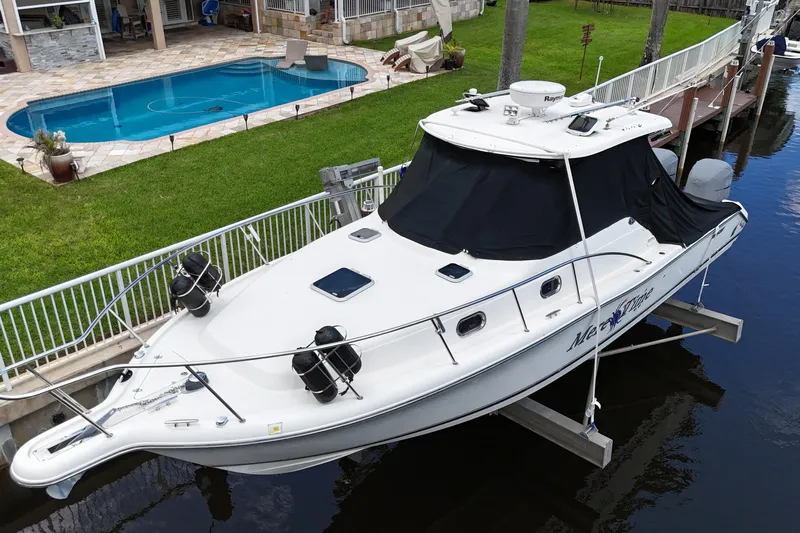  Yacht Photos Pics 2007 Pursuit OS 335 Offshore boat docked near a poolside patio.