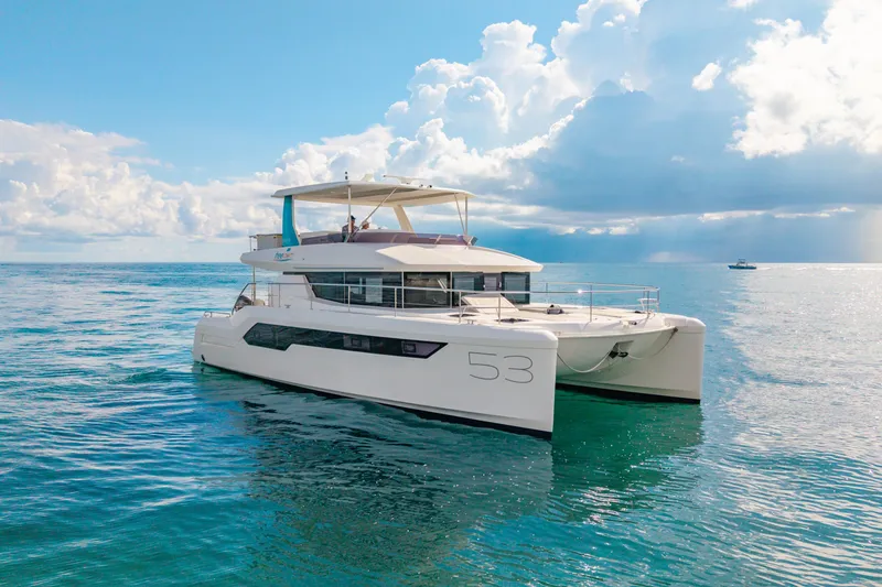 Freedom Yacht Photos Pics 2022 Leopard 53 Powercat yacht on calm ocean waters under a partly cloudy sky.