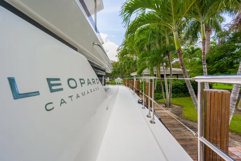 Freedom Yacht Photos Pics 2022 Leopard 53 Powercat yacht docked near tropical palm trees.