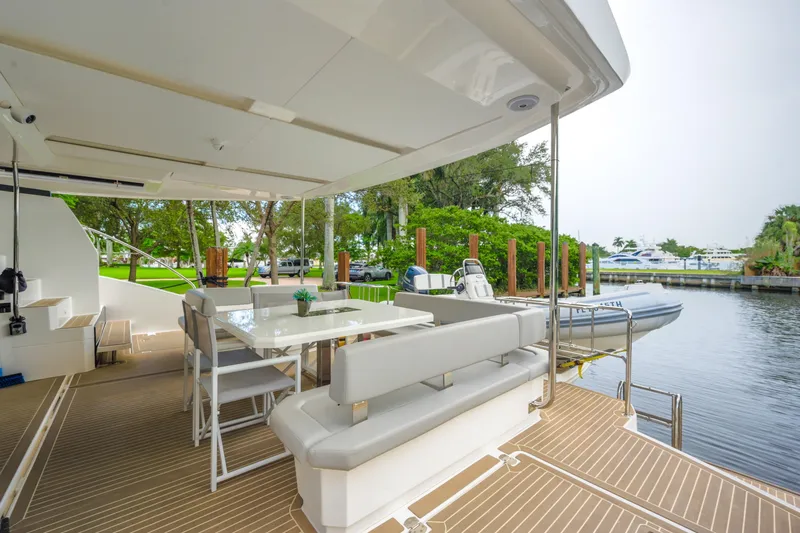 Freedom Yacht Photos Pics 2022 Leopard 53 Powercat yacht deck with seating and dining area by the water.