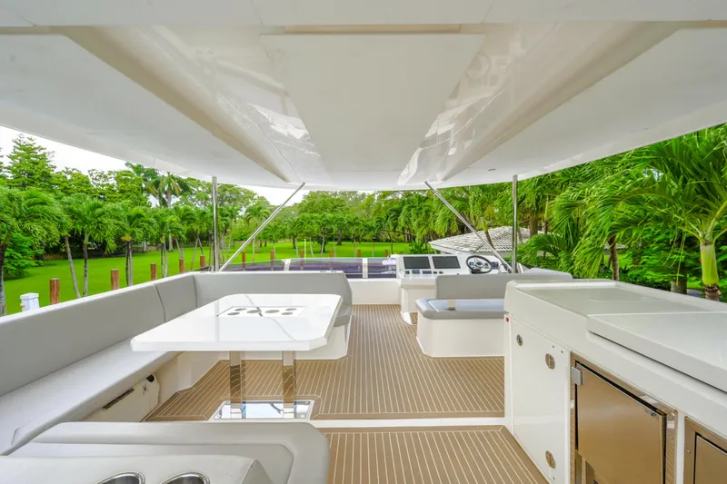 Freedom Yacht Photos Pics 2022 Leopard 53 Powercat yacht interior with seating, table, and lush greenery view.