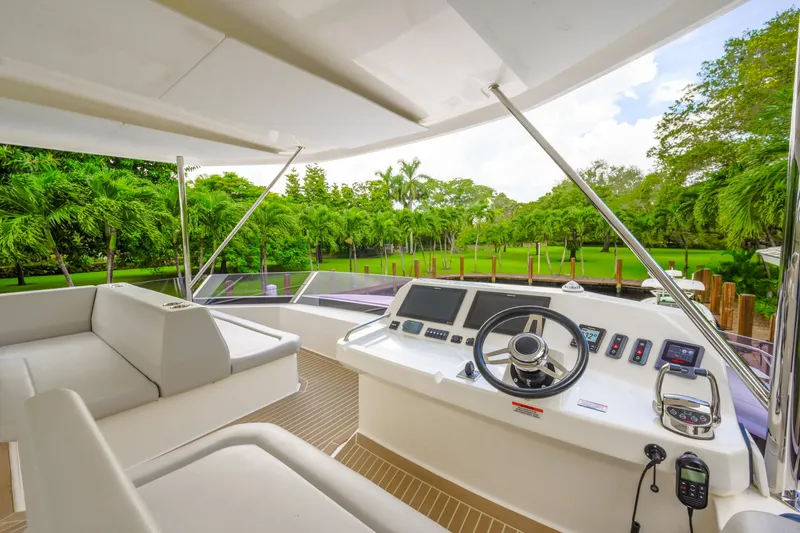 Freedom Yacht Photos Pics Luxurious 2022 Leopard 53 Powercat yacht helm with lush green landscape view.