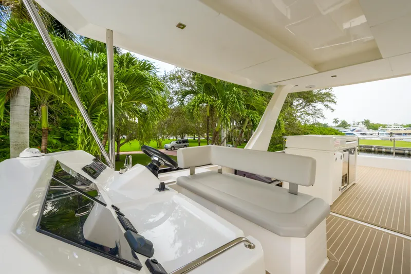 Freedom Yacht Photos Pics 2022 Leopard 53 Powercat yacht interior with helm, seating, and lush greenery view.