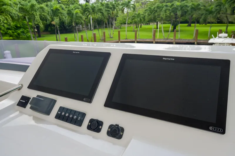 Freedom Yacht Photos Pics 2022 Leopard 53 Powercat helm with dual Raymarine displays, surrounded by lush greenery.