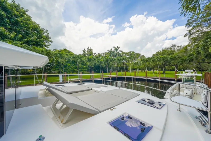 Freedom Yacht Photos Pics Luxurious 2022 Leopard 53 Powercat yacht docked by lush greenery and calm waters.