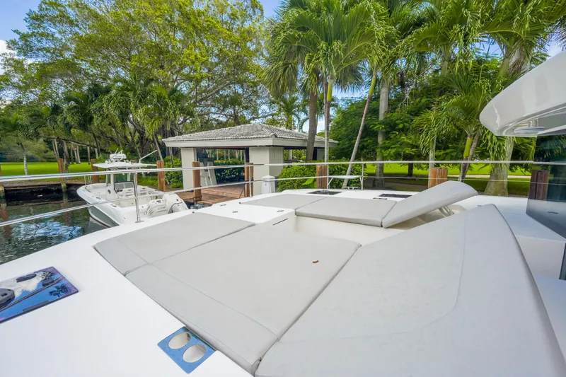 Freedom Yacht Photos Pics Luxurious 2022 Leopard 53 Powercat yacht with sunbathing deck, surrounded by lush greenery.