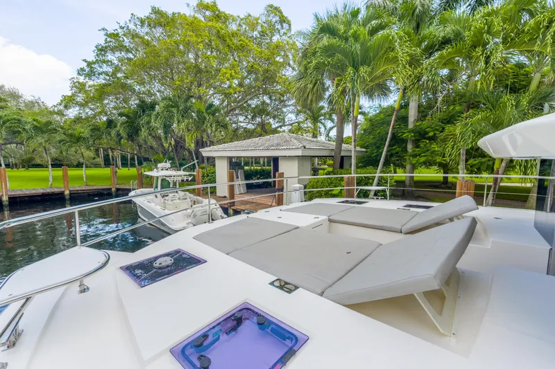 Freedom Yacht Photos Pics Luxurious deck of 2022 Leopard 53 Powercat yacht with sun loungers and lush surroundings.