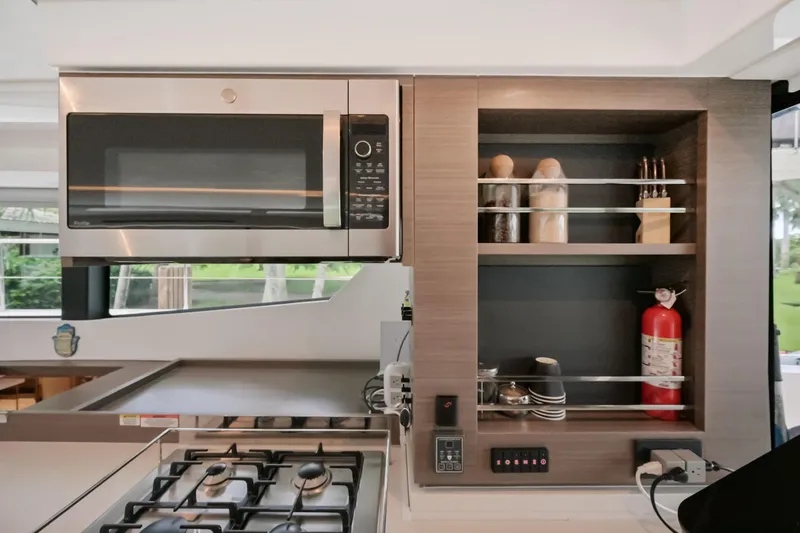 Freedom Yacht Photos Pics Modern kitchen in 2022 Leopard 53 Powercat with microwave, stove, and storage shelves.