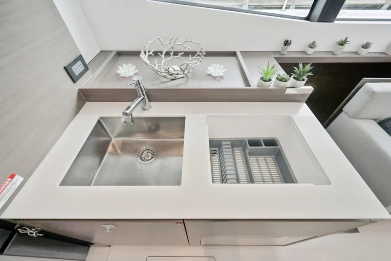 Freedom Yacht Photos Pics Modern kitchen sink area on 2022 Leopard 53 Powercat with sleek design and decorative plants.