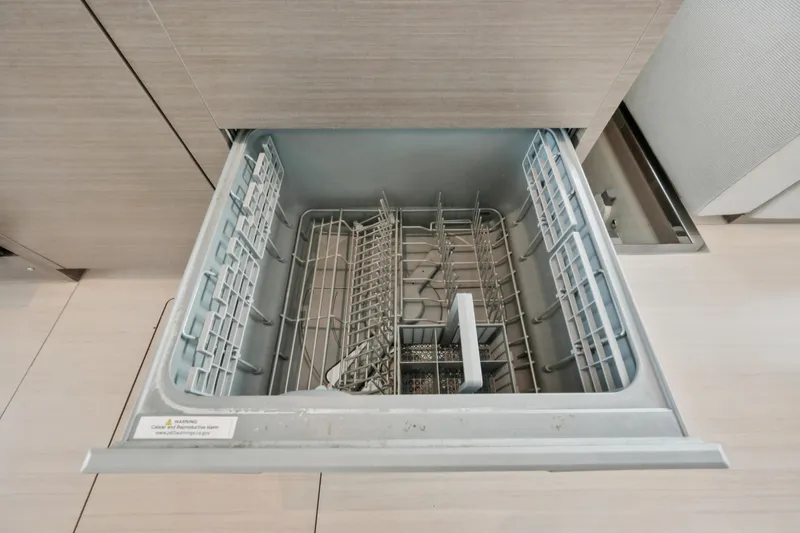 Freedom Yacht Photos Pics Open dishwasher drawer on Leopard 53 Powercat 2022 yacht, showcasing modern kitchen amenities.