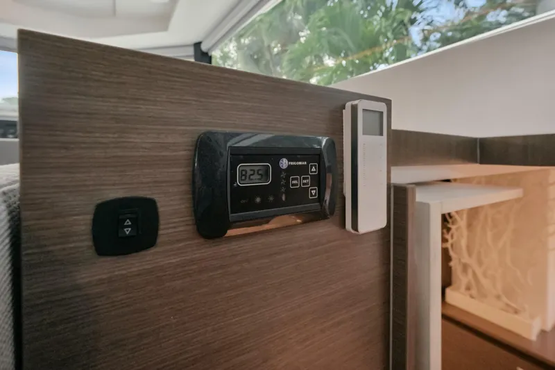 Freedom Yacht Photos Pics Control panel on 2022 Leopard 53 Powercat yacht interior, featuring digital display and remote.